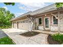 Charming home featuring a three-car garage and beautifully landscaped front yard with brick facade at 7220 Normandy Way, Indianapolis, IN 46278