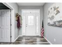 Bright foyer with hardwood floors, a decorative front door with sidelights and transom, and gray painted walls at 749 Bracknell Dr, Avon, IN 46123