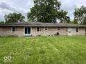 View of backyard showing the exterior elevation of the home's rear, windows, and sliding glass door at 8045 Briarwood Dr, Indianapolis, IN 46227