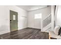 Bright entryway with dark wood floors, a modern door, and a staircase with black metal railings at 805 N Temple Ave, Indianapolis, IN 46201