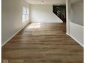 Spacious living room featuring hardwood floors, natural light, and stairs to the second level at 832 Spinney Ln, Whiteland, IN 46184