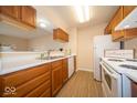 A quaint kitchen with wood cabinets, modern appliances, and neutral countertops at 8410 Hague Rd # 5, Indianapolis, IN 46256