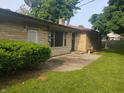 Back exterior of stone-clad home with a patio and lush greenery at 1050 E 106Th St, Carmel, IN 46280