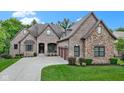 Lovely brick home with a three-car garage, a well-maintained lawn and concrete driveway at 11393 Muirfield Trce, Fishers, IN 46037