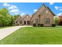 Attractive brick home features mature landscaping and a long driveway leading to a three-car garage at 11393 Muirfield Trce, Fishers, IN 46037