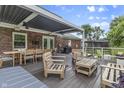 Relaxing outdoor living space featuring a pergola-covered deck, comfortable seating, and outdoor dining area at 11409 Haverstick Rd, Carmel, IN 46033