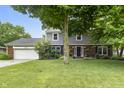 Charming two-story home featuring a brick and siding facade, attached two-car garage and beautiful landscaping at 11409 Haverstick Rd, Carmel, IN 46033