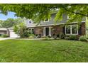 Inviting two-story home with brick and siding exterior, lush lawn, mature trees and well-maintained landscaping at 11409 Haverstick Rd, Carmel, IN 46033