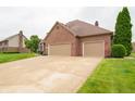 Beautiful home showcasing a three-car garage, brick exterior, and a well-maintained driveway at 1145 Forest Commons Dr, Avon, IN 46123