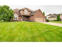 Charming two-story home with a brick and siding exterior, lush green lawn, and a welcoming front porch at 1145 Forest Commons Dr, Avon, IN 46123