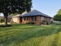Charming brick home featuring an attached garage, mature trees, and a well-maintained lawn at 1201 Briarwood Dr, Brownsburg, IN 46112