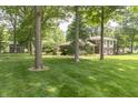 Spacious backyard features mature trees and a grassy area, perfect for outdoor activities at 12014 Briar Way Center Dr, Indianapolis, IN 46126