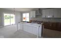 Future kitchen featuring white cabinets, an island, and sliding glass door to backyard at 12338 French Cattle Way, Noblesville, IN 46060