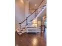 Grand staircase featuring hardwood floors and an accent table at 13429 Boxelder Ct, Carmel, IN 46074