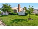 A sprawling green lawn surrounds the rear of this home featuring mature trees and a white picket fence at 1510 Dominion Dr, Zionsville, IN 46077