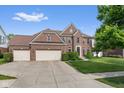 Charming brick home with a three-car garage, lush lawn, and inviting front entrance at 15515 Alameda Pl, Westfield, IN 46074