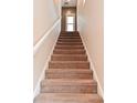 Carpeted staircase leading upstairs with white banister and natural light at 1635 N College Ave # 4, Indianapolis, IN 46202