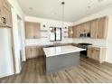 Modern kitchen featuring granite countertops, stainless steel appliances, grey island, and hardwood flooring at 1663 Fernley Dr, Westfield, IN 46074