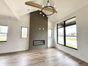 Open-concept living room featuring hardwood floors, large windows, fireplace with wooden beam, and modern lighting fixture at 1663 Fernley Dr, Westfield, IN 46074