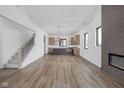 Open-concept living space with hardwood floors, modern fireplace, staircase, and gourmet kitchen at 1663 Fernley Dr, Westfield, IN 46074