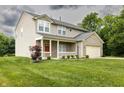 Attractive two-story home with a covered porch, brick accents, two-car garage, and a lush green lawn at 19187 Outer Bank Rd, Noblesville, IN 46062