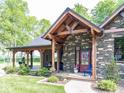 Charming home featuring a covered porch, stone accents, and beautiful landscaping at 2004 Layton Rd, Anderson, IN 46011