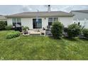 Spacious backyard featuring a patio, garden area, and lush green lawn at 2302 Rolling Oak Dr, Indianapolis, IN 46214