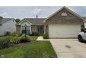 Inviting brick home featuring a lush front yard with flower beds at 2302 Rolling Oak Dr, Indianapolis, IN 46214