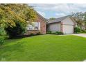 Home featuring a well-kept lawn, brick facade, attached garage, and mature landscaping at 293 E Quail Wood Ln, Westfield, IN 46074
