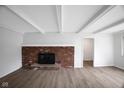 Living room showcases wood floors, white-painted ceiling beams, and brick fireplace at 3148 Arbutus Dr, Indianapolis, IN 46224