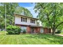 Charming two-story home featuring a brick facade, complemented by a well-maintained lawn and mature trees at 3425 Ireland Dr, Indianapolis, IN 46235