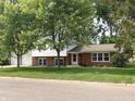 View of a home's front exterior, showcasing well-maintained landscaping and mature trees at 3520 Lantern Ln, Columbus, IN 47203