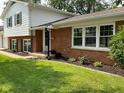 Front yard view of brick home with updated windows and landscaped garden at 3520 Lantern Ln, Columbus, IN 47203