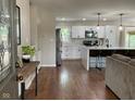 Open-concept kitchen features white cabinets, stainless steel appliances, and hardwood floors at 3520 Lantern Ln, Columbus, IN 47203
