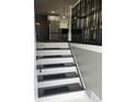 View of staircase leading to a modern kitchen featuring white cabinetry and stainless steel appliances at 3949 Chateau Dr, Indianapolis, IN 46226