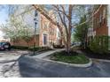Attractive brick townhome with mature trees and a paved walkway leading to the entrance at 420 Beverly Ct, Carmel, IN 46032