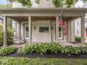 Inviting front porch with swing, featuring wood ceiling, brick accents, and view of lawn at 4455 Central Ave, Indianapolis, IN 46205