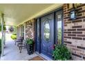 Elegant front porch featuring a decorative front door, brick accents, and comfortable seating at 47 Oakwood Ct, Brownsburg, IN 46112