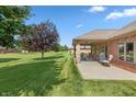 A spacious backyard with a covered patio, expansive lawn and mature trees at 5229 Imperial Dr, Columbus, IN 47203