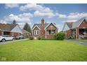 Beautiful brick home with a spacious front yard, mature trees, and a welcoming neighborhood feel at 5435 E 10Th St, Indianapolis, IN 46219