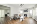 Bright living room with hardwood floors and a cozy fireplace with white painted brick at 5516 W Minnesota St, Indianapolis, IN 46241