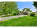 Inviting single-story home showcasing lush green lawn, mature tree, and a convenient attached carport at 623 Circle Ct, Whiteland, IN 46184