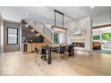 Elegant dining room with a modern chandelier, sleek fireplace, and a stylish staircase at 631 1St Nw Ave, Carmel, IN 46032