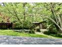 Single-story brick house with an inviting lawn, mature trees, and visible driveway at 6519 Creekside Ln, Indianapolis, IN 46220