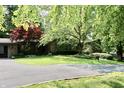 Charming single-story brick home with a well-manicured lawn, mature trees, and circular driveway at 6519 Creekside Ln, Indianapolis, IN 46220