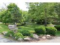An inviting street view showcases the lush landscaping, mature trees, and attractive mailbox with the house number at 6519 Creekside Ln, Indianapolis, IN 46220