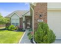 Attractive brick home features a tidy, landscaped front lawn and a well-lit entrance for welcoming guests at 6529 Lakesedge Dr, Indianapolis, IN 46237