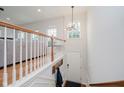 Bright entryway with hardwood floors, coat rack, chandelier, and staircase at 755 Ivy Ln, Carmel, IN 46032