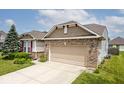 Charming single Gathering home features a well-maintained lawn, mature landscaping, and a two-car attached garage at 8176 Crumwell Dr, Avon, IN 46123