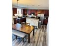 Open kitchen and dining area with stainless steel appliances and modern light fixtures at 8176 Crumwell Dr, Avon, IN 46123
